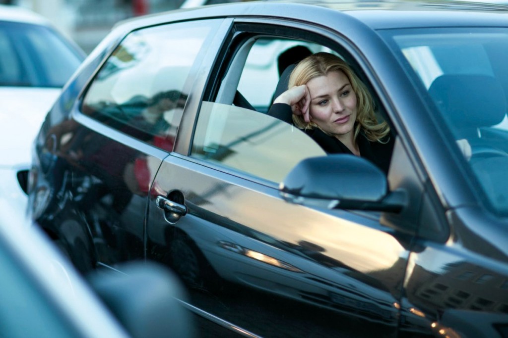 Bored businesswoman driving in city traffic jam