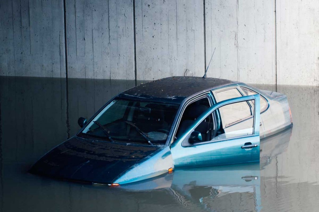 Blue-car-flooded-on-a-freeway-with-door-left-open