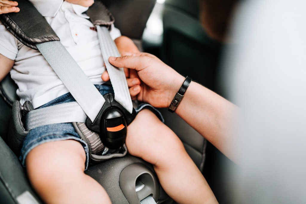 details of child car seat with baby inside, seatbelt and safety