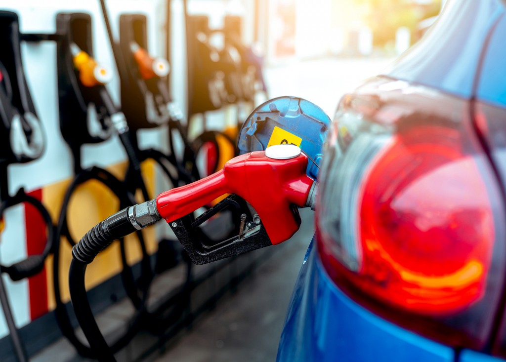 Car fueling at gas station. Refuel fill up with petrol gasoline. Petrol pump filling fuel nozzle in fuel tank of car at gas station. Petrol industry and service. Petrol price and oil crisis concept.