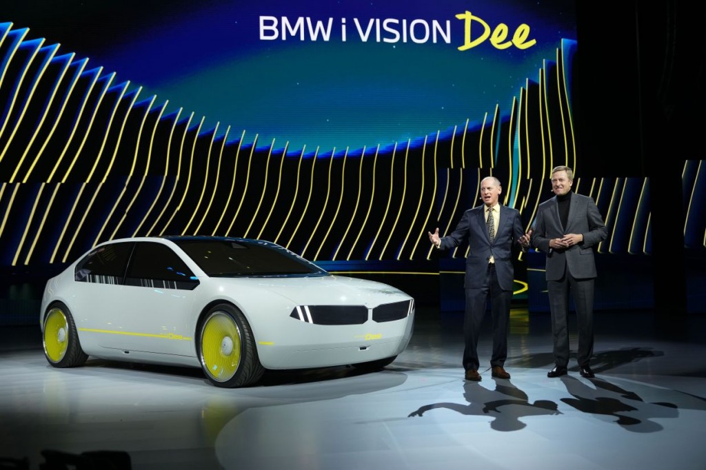 Gary Shapiro, president and chief executive officer of Consumer Technology Association, left, stands with Oliver Zipse, chairman of the board of management of BMW AG, during a pre-show keynote introducing the BMW I Vision Dee at CES 2023 Wednesday, Jan. 4, 2023, in Las Vegas. (AP Photo/Jack Dempsey)