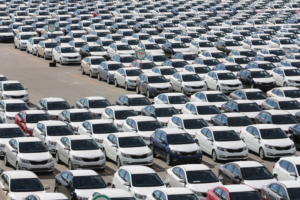 Completed Kia Rio vehicles sit with body panels covered in protective wrapping ahead of distribution in a parking lot outside the Hyundai Motors Corp. automobile plant in St Petersburg, Russia, on Friday, Aug. 14, 2015. By volume, Hyundai Kia is the largest automaker in Russia, holding that position as its 15% decline in unit year-to-date sales is the third best performance of all automakers selling in Russia. Photographer: Andrey Rudakov/Bloomberg